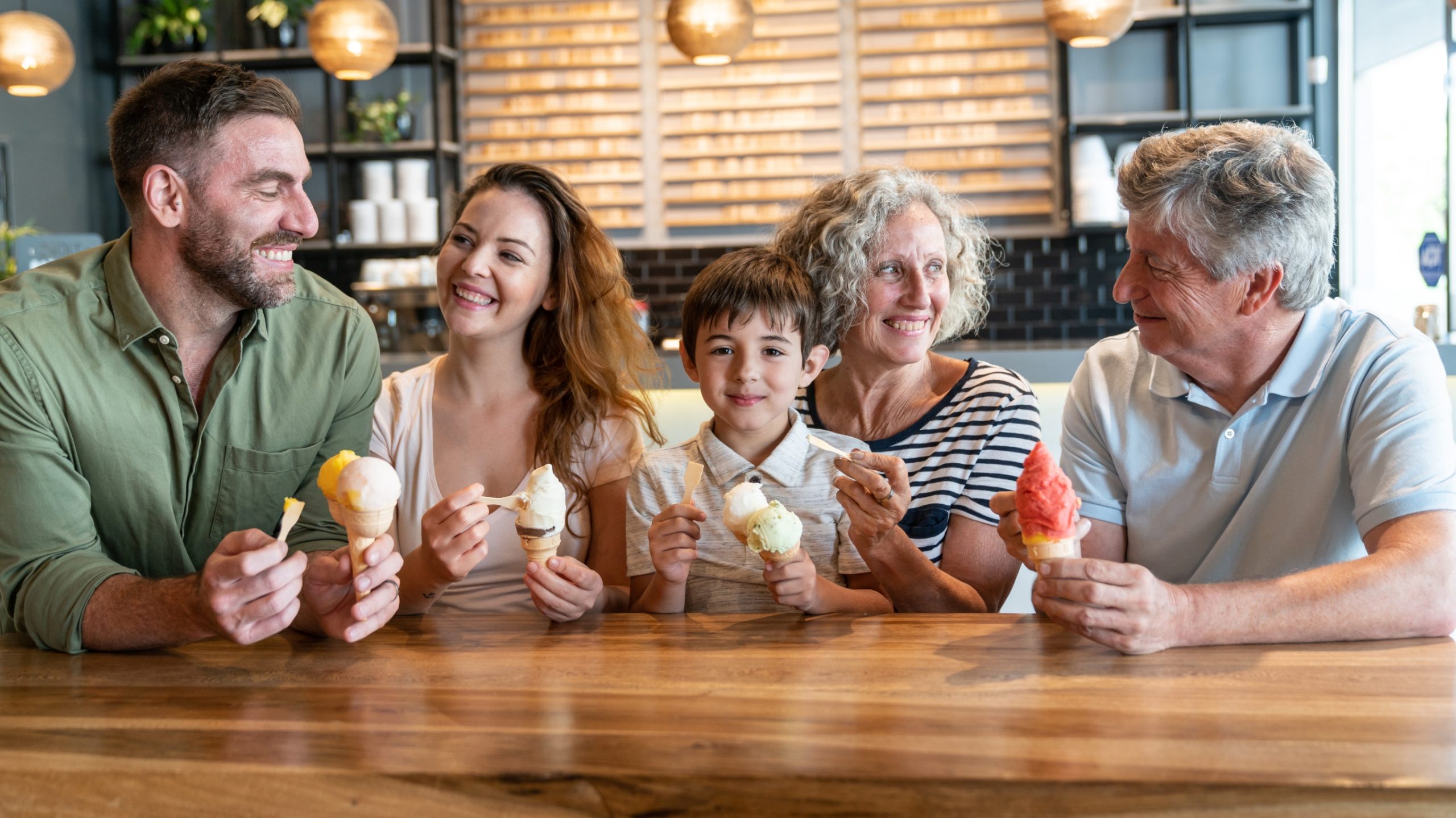 three generations of family sitting at a table enjoying ice ream