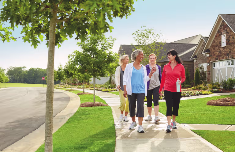 group of women walking on sidewalk together in a suburban neighborhood