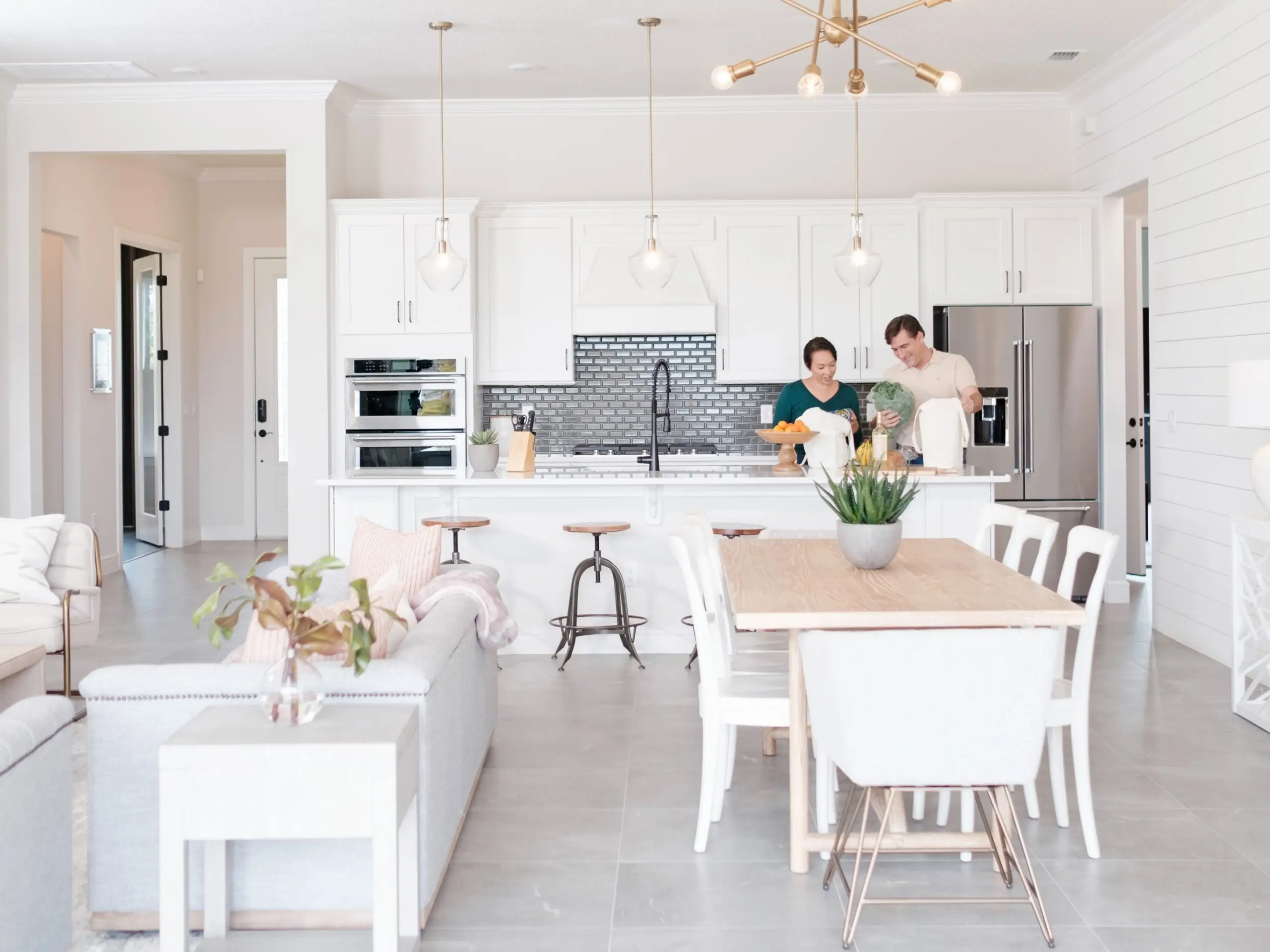 couple unpacking groceries in thier open concept kitchen on the island