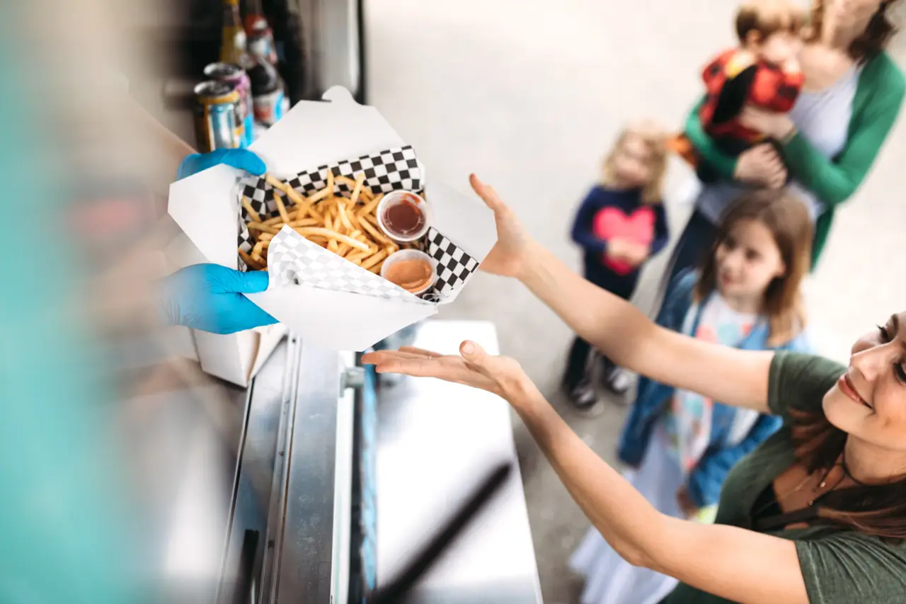 Woman Receiving Order at Food Truck