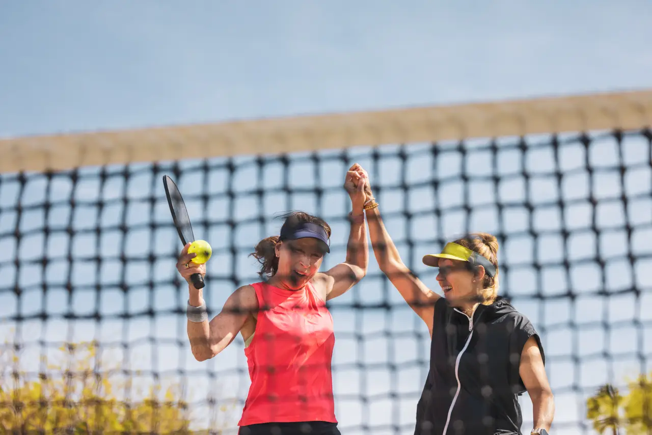 Two women sharing a high five after a pickleball game