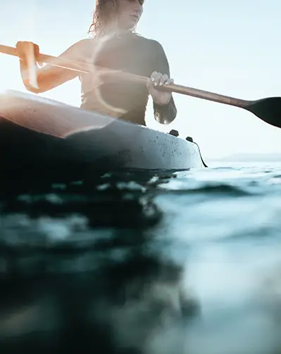 close up of a woman canoeing on a lake